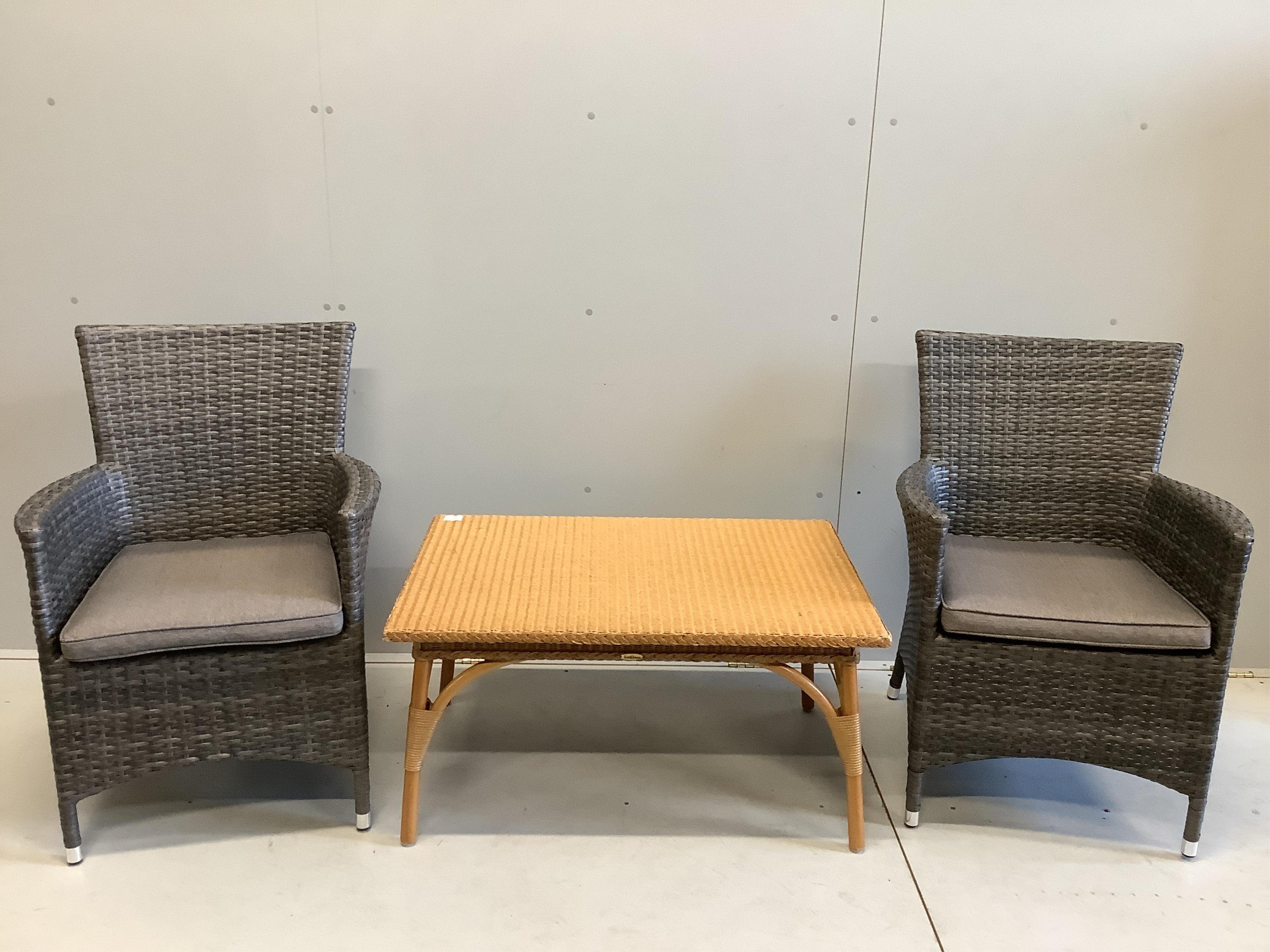 A pair of all weather rattan garden chairs with cushions, width 63cm, depth 56cm, height 90cm together with a rectangular rattan conservatory table. Condition - good